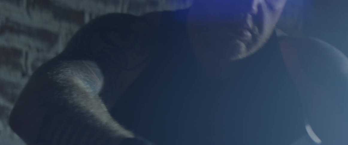 Man sits looking down at his hands