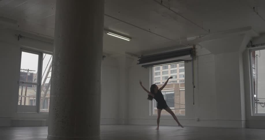 A woman is doing ballet in a room