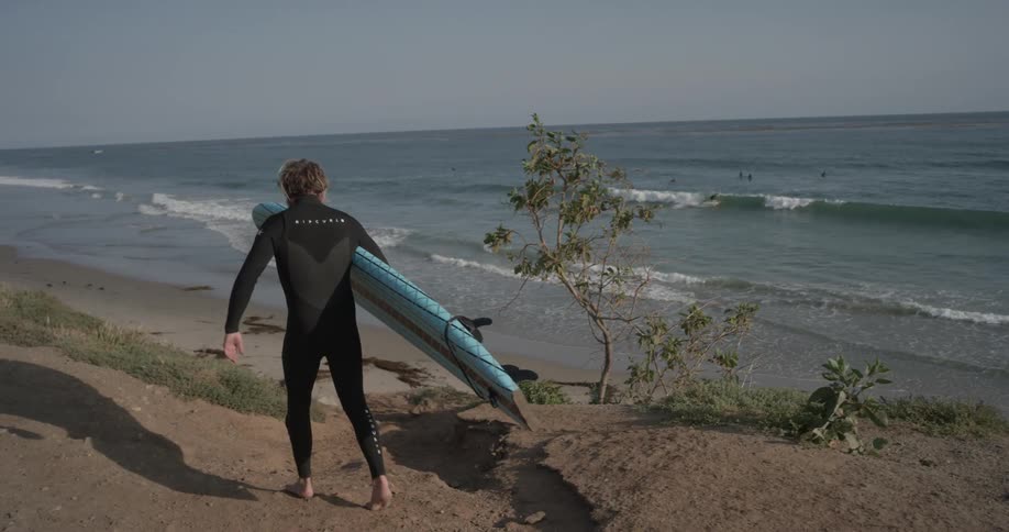 A man is outside with a surfboard