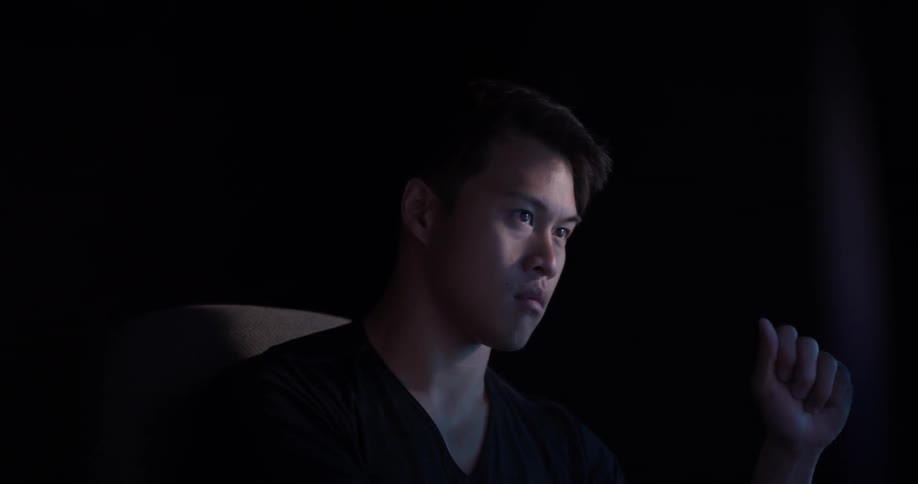 A man sitting at a desk looking at computer screens