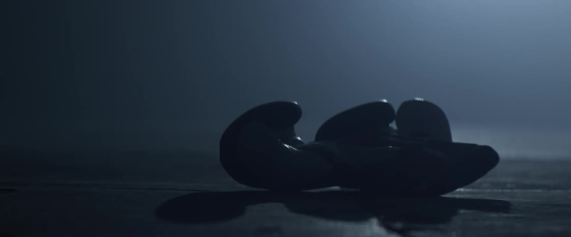A pair of boxing gloves that are falling to the floor