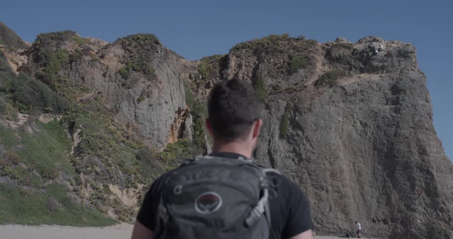 A man is walking near a mountain