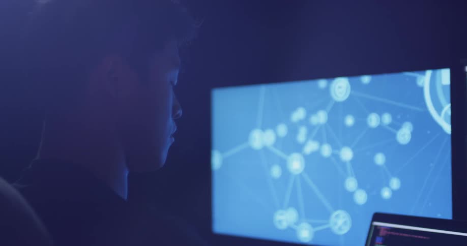 Man sitting in the dark staring at a computer screen