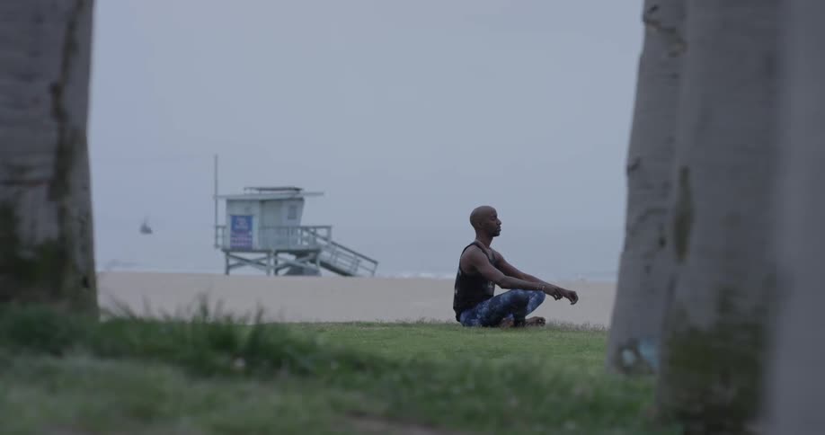Man sits in the grass meditating