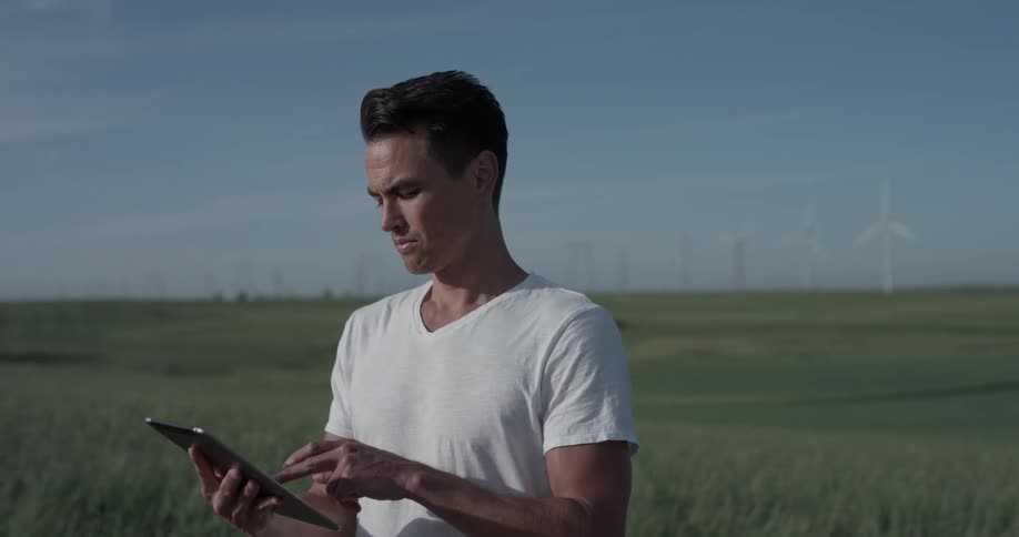 Man Driving Electric Car Through Wind Farm