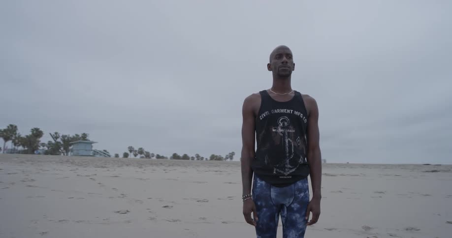 Man claps hands while standing on the beach