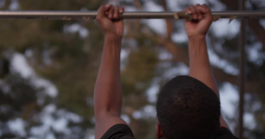 A man doing pull ups at a park