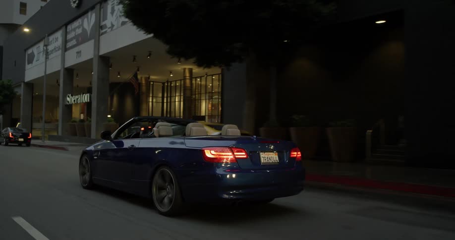 A person that is driving a convertible in a city