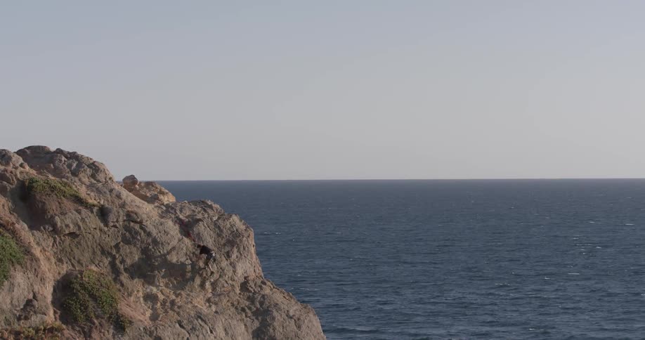 Man Climbing Wall By The Beach