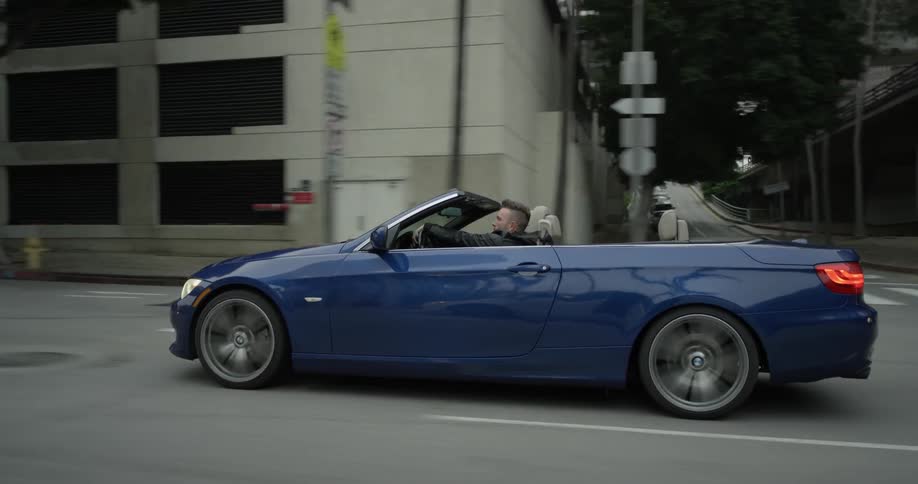 A car is driving down the city street