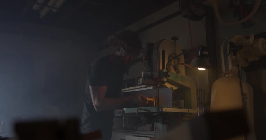 Man working in a wood shop with a saw