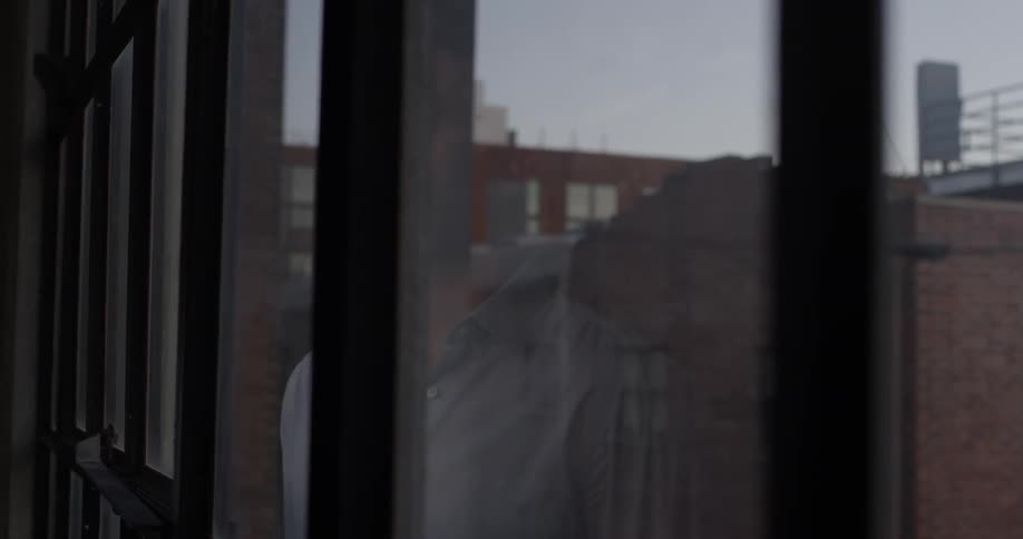 A man is looking out the window