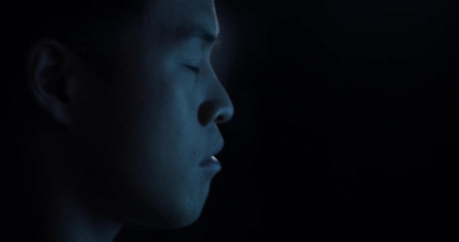 A man looking up and down at bright screens