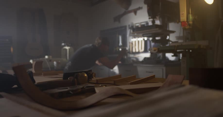 A man that is working on a machine in a wood shop