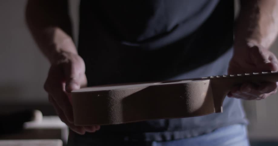 Carpenter Making Guitar In Workshop