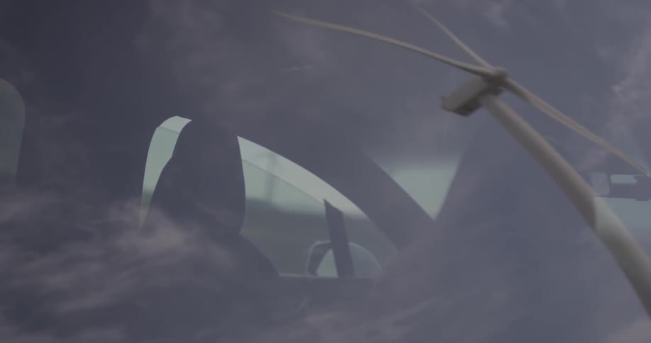 A  man enters a car while a windmill spins