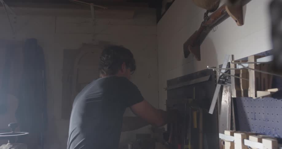 A man hangs an object on the wall