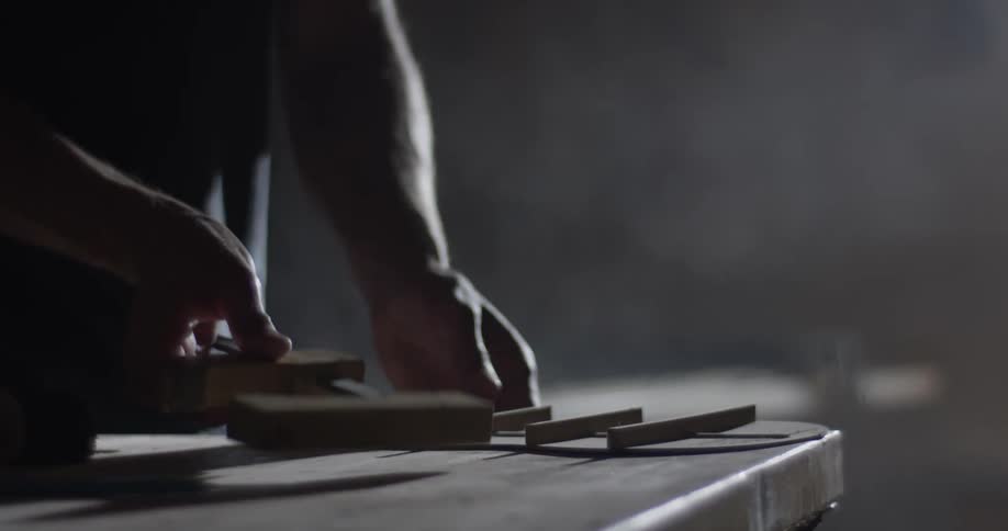Woodworker removing clamps from an object