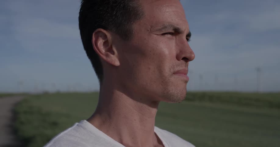 A man looking into the distance and squinting on a sunny day