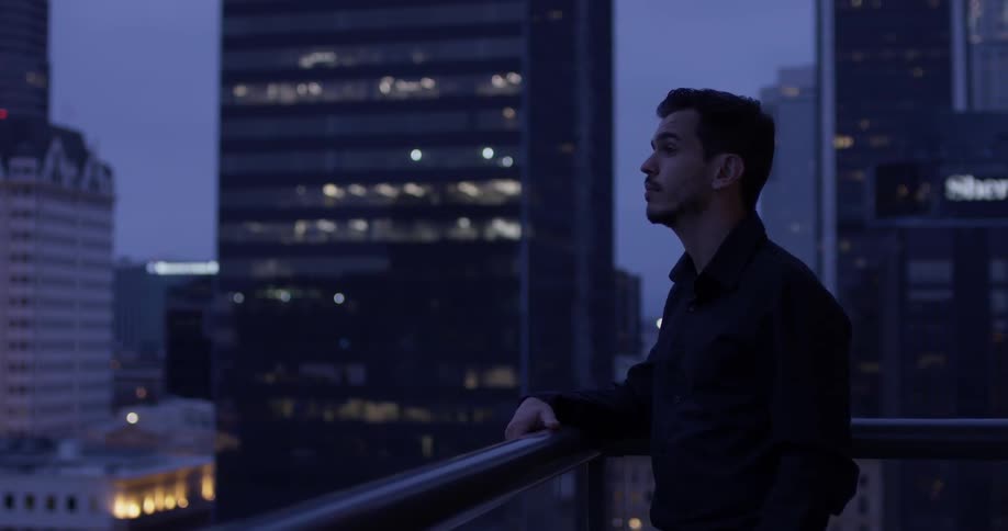 A man grasps the rooftop railing
