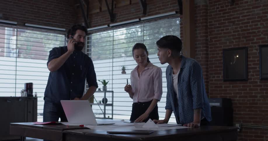 Three people in an office figuring out details