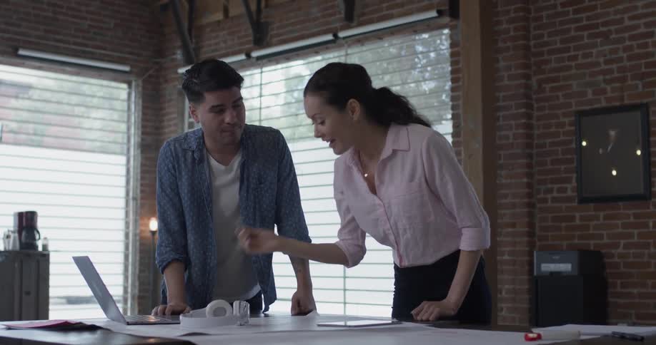 Man and woman discussing work on a table in front of them