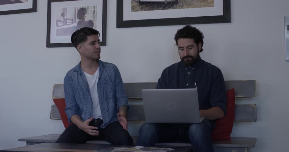 Two people discussing what is displayed on a laptop in an office