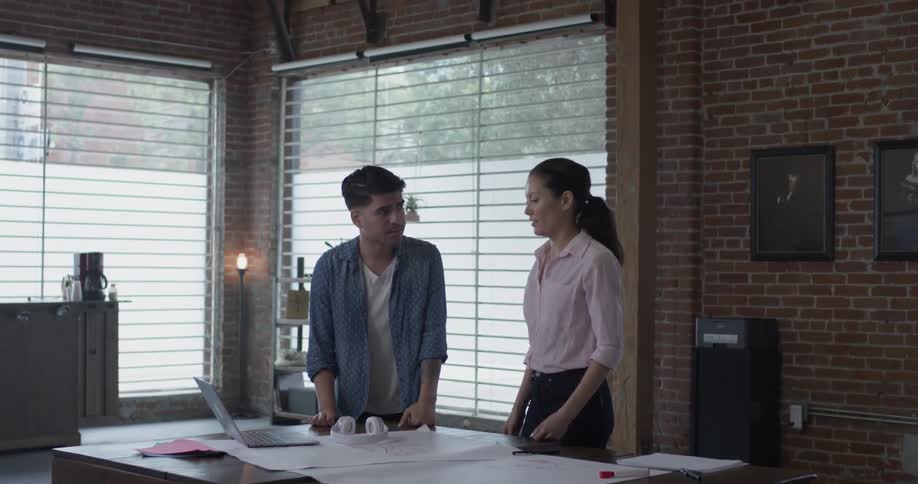 Man and woman in an office discuss a project