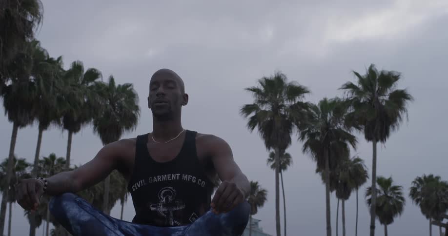 Man meditating outdoors with cloudy skies