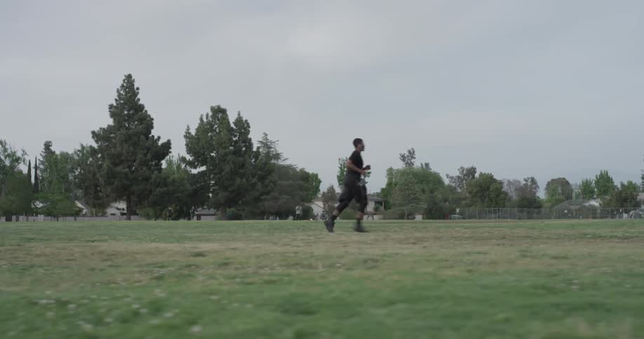 A man jogging through an open grass area