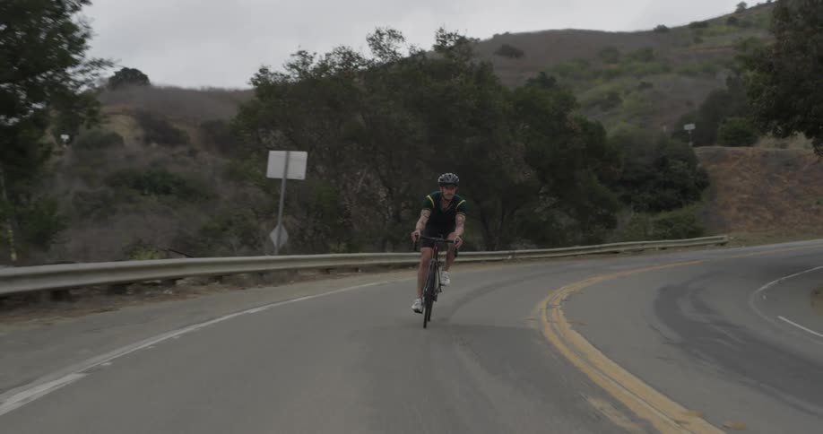 A man is biking down the road