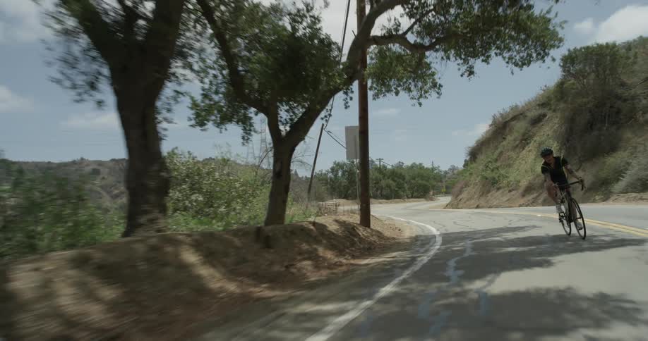 A man riding a bicycle down a mountain road