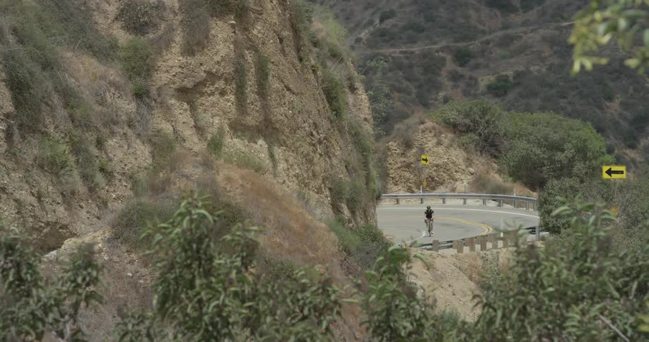 A person is biking along the mountainside