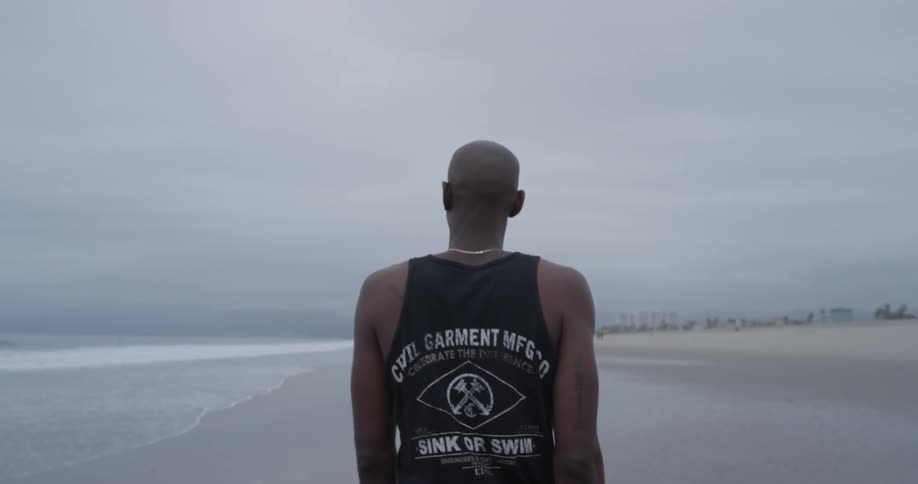 A man walking down the edge of the coast