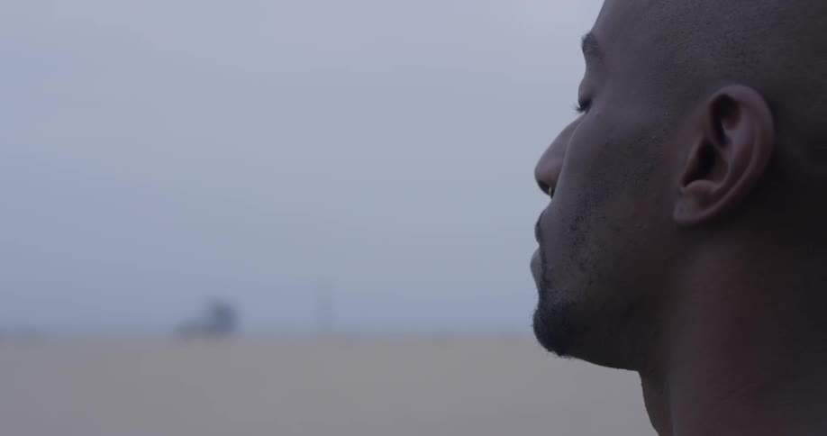 A man doing meditation next to the beach