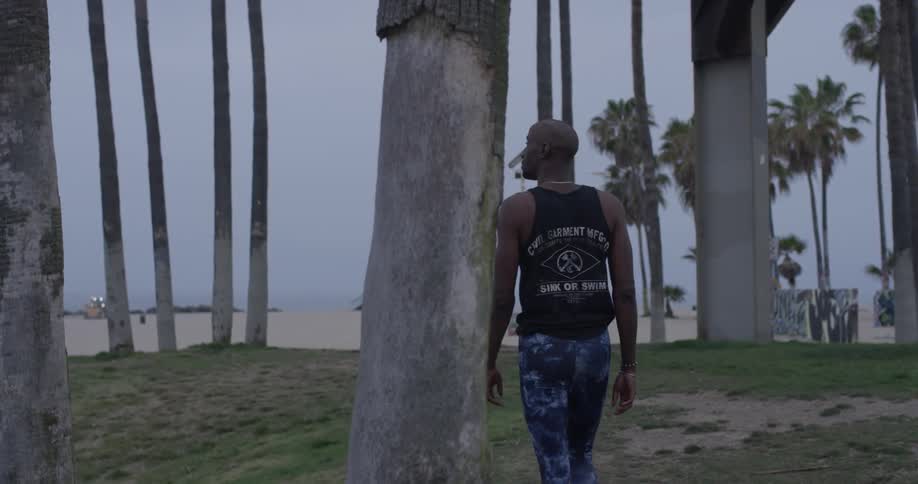 A man walking between some trees