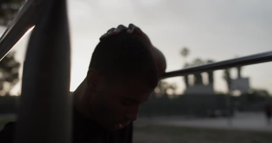 A man rests his arm on a bar as he takes a breath