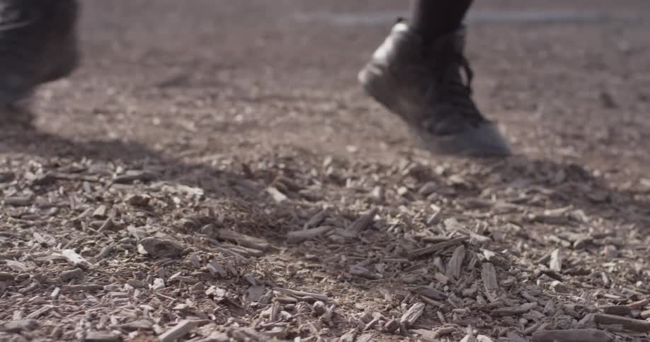 A person bounces on their toes on top of mulch