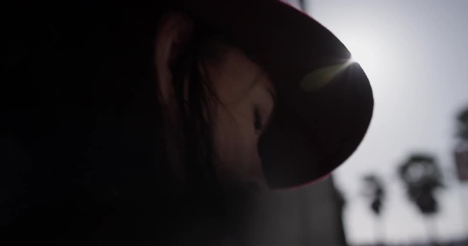 A woman in a hat walking down the street in a hat and leather jacket