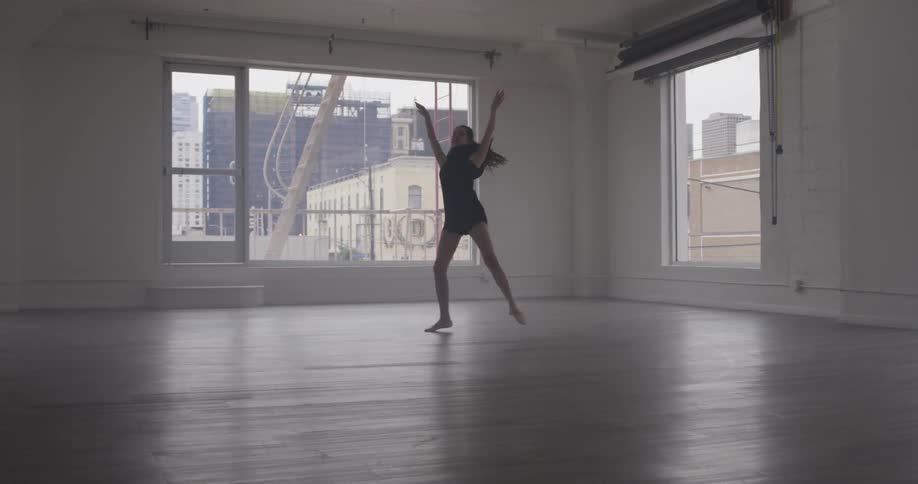 A dancer practices dancing in an empty studio