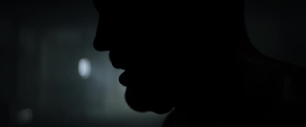 A man sways back and forth in a dark room