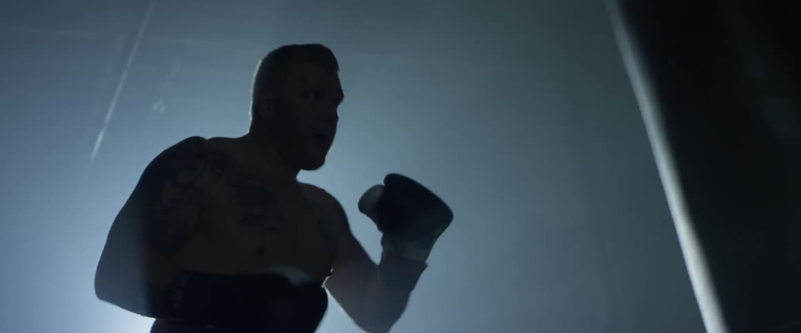 Man boxes heavy bag in dark room