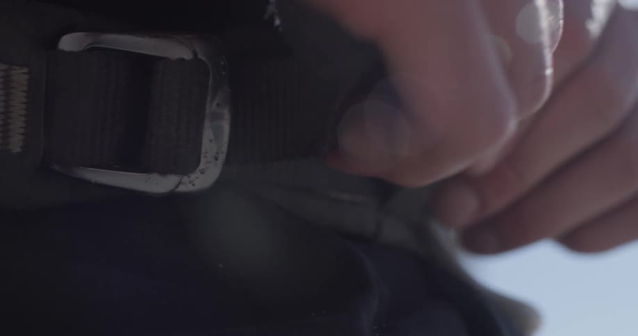 A person tightens their belt around their waist