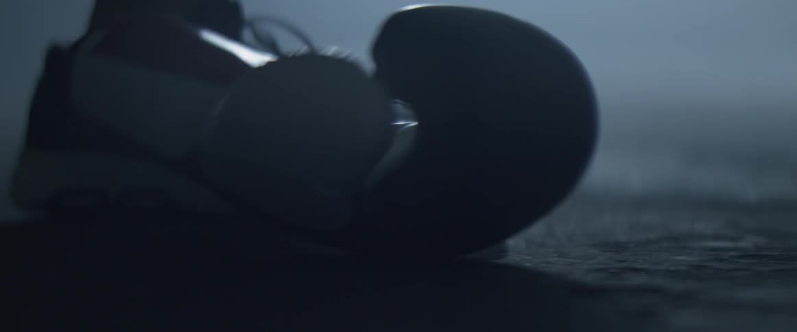 A person picking up a boxing glove off the ground