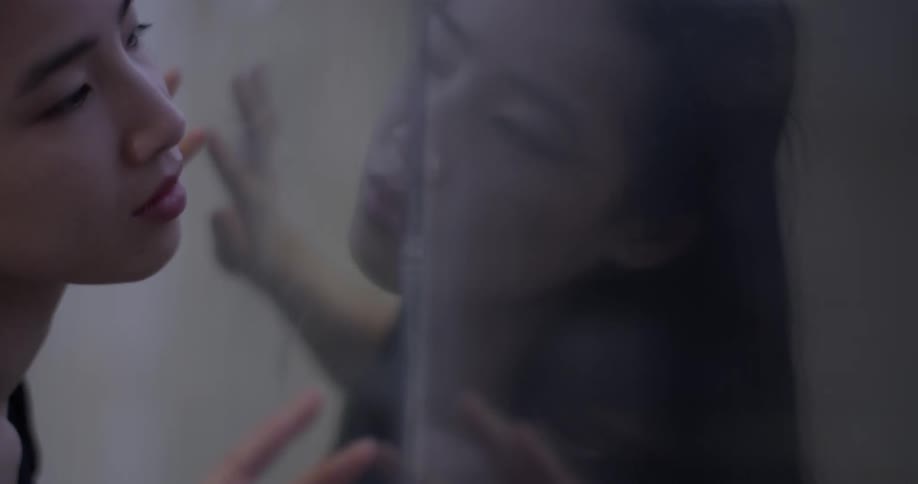 Woman stretches while watching reflection in glass