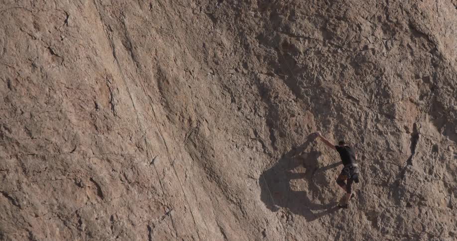 A man is climbing up a cliff