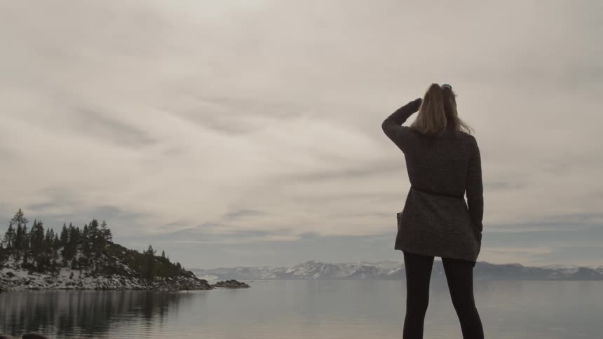 Woman stares at snow covered hills