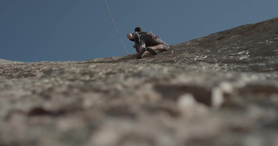Person climbs rock face