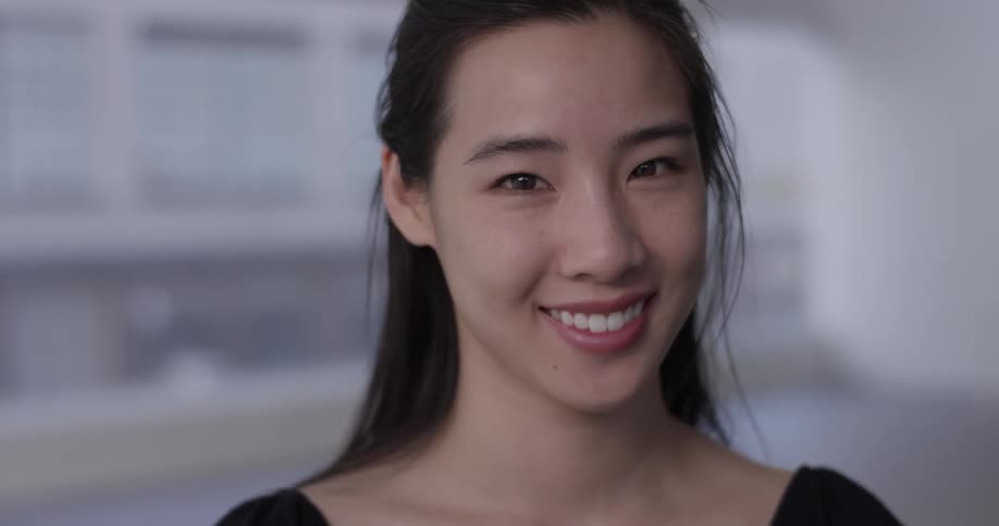 A young asian woman smiles at the camera