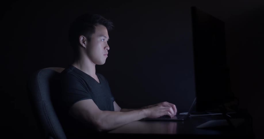 A man sitting at a desk typing on a keyboard